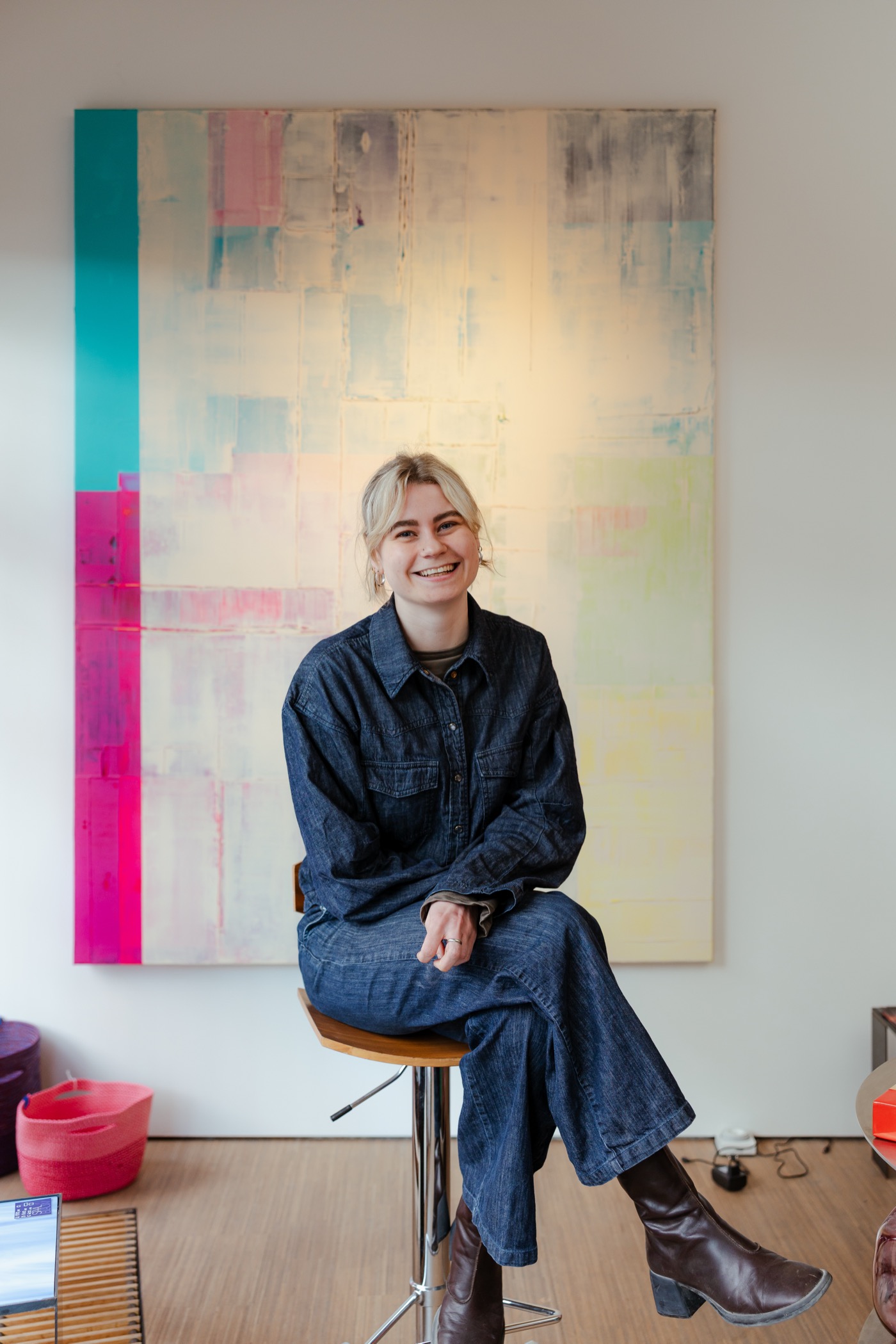 Alanis Blondeel in haar atelier voor een van haar kleurrijke schilderijen