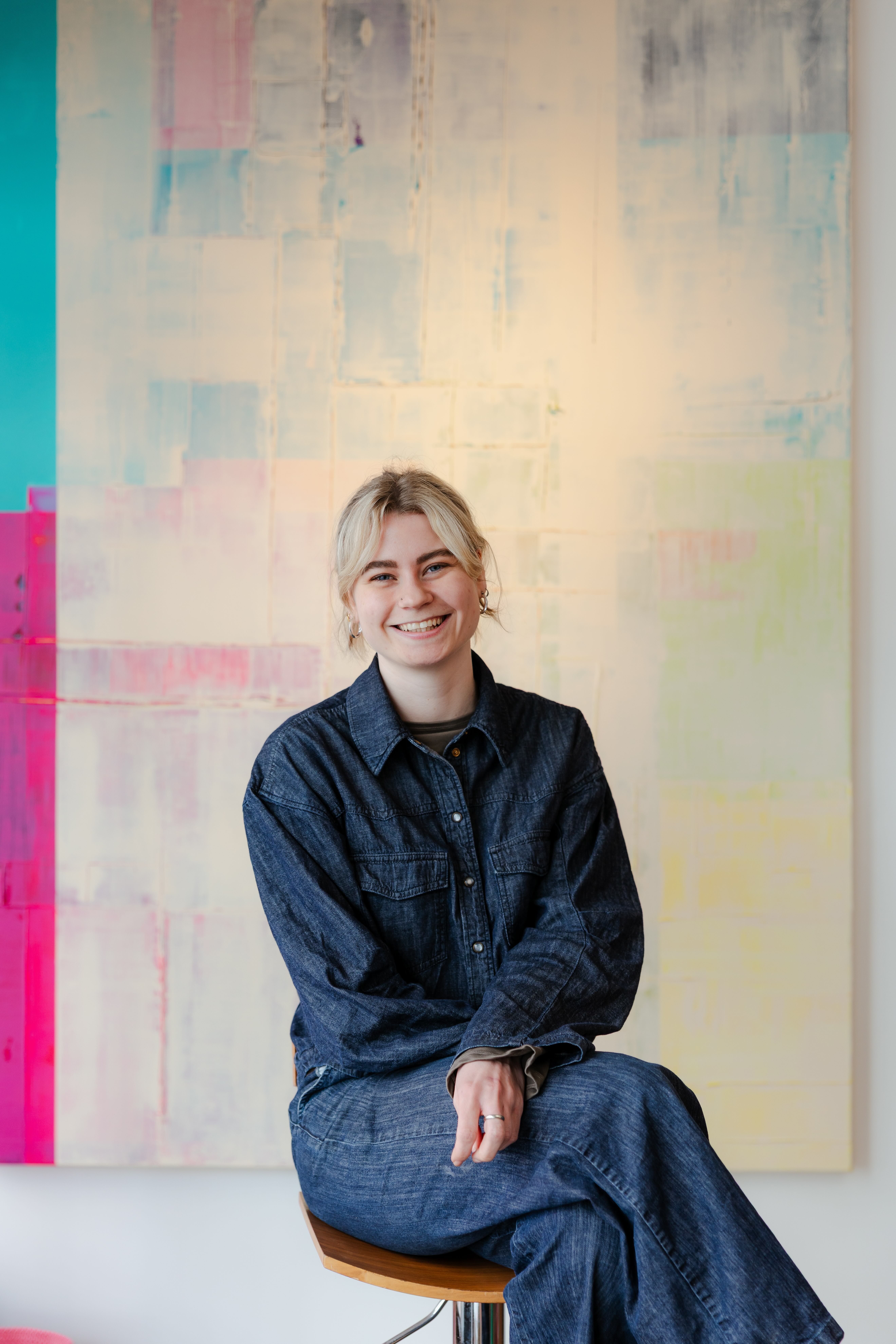 Alanis Blondeel in haar atelier voor een van haar kleurrijke schilderijen